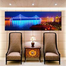 Load image into Gallery viewer, blue  city  beach  wall  art  night  lights  water  reflection  bay  cross  sea  bridge  panoramic  canvas  print In Living Room
